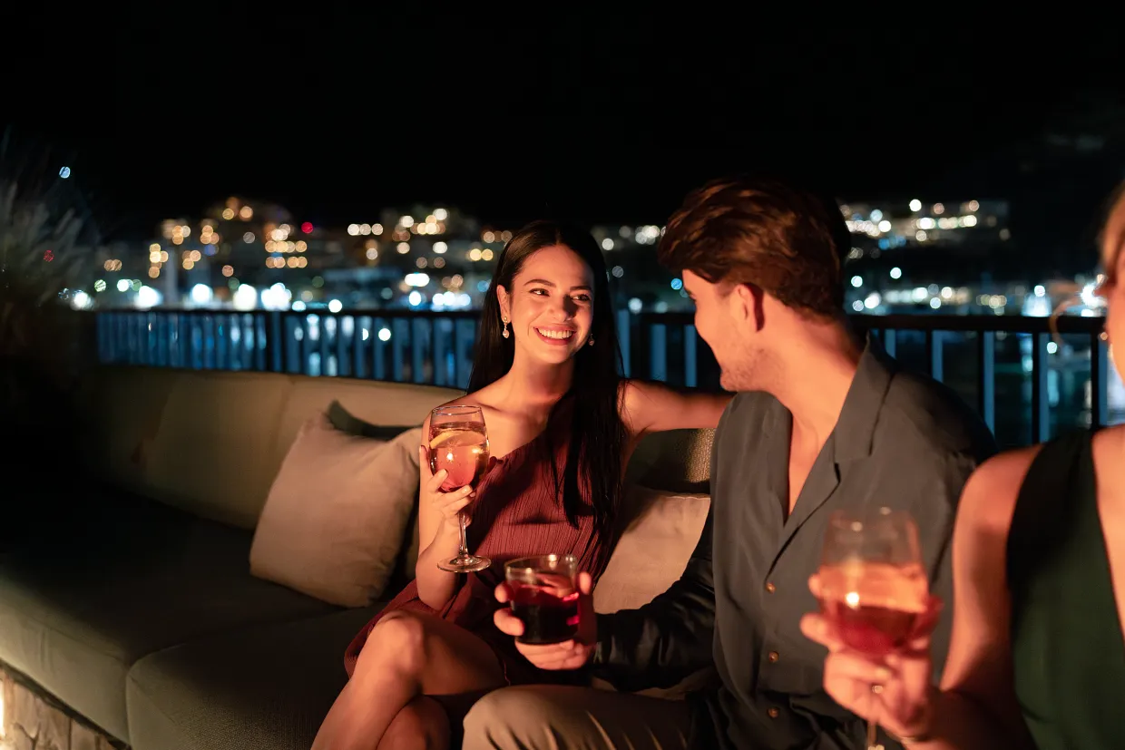 Couple enjoying cocktails at night overlooking the marina at Breathless Cabo San Lucas
