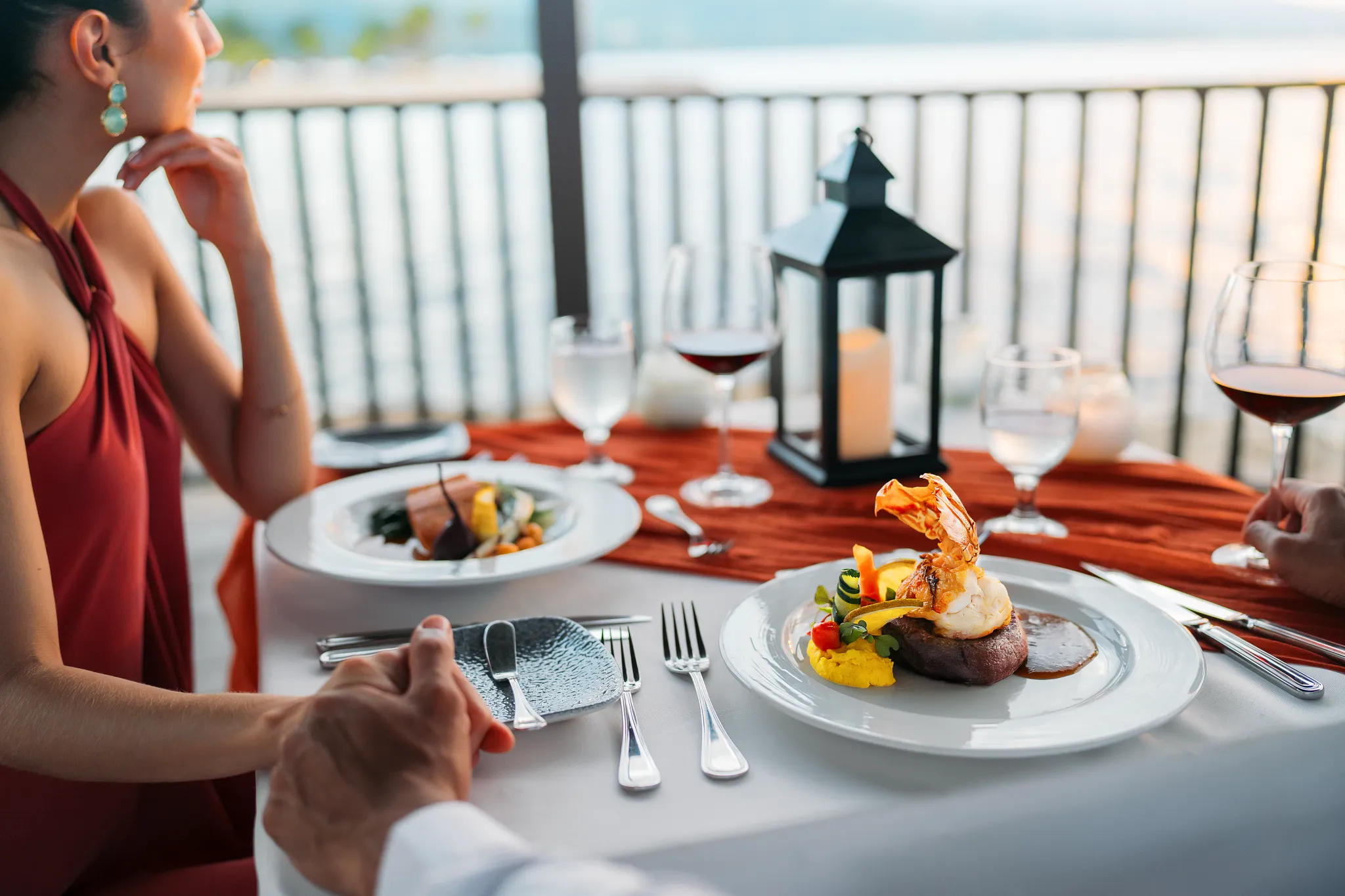 Couple enjoying a gourmet oceanfront dinner with wine at Secrets St. James Montego Bay in Jamaica.