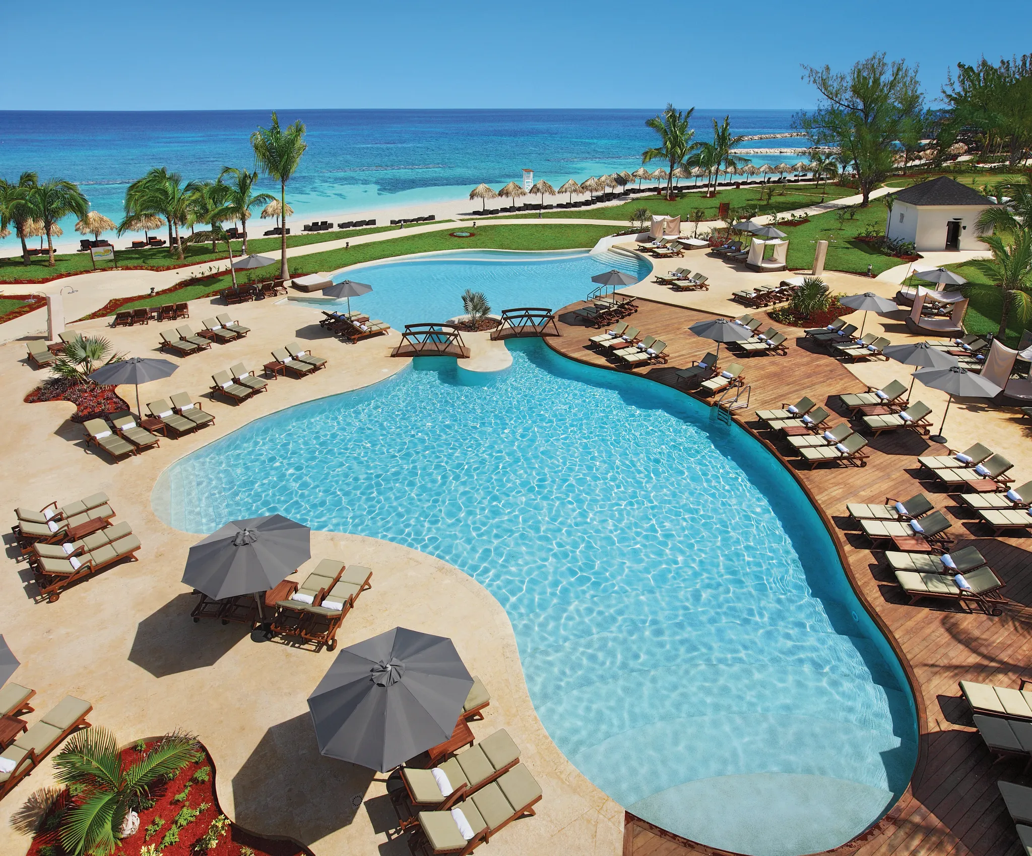 Large resort pool with lounge chairs and ocean views at Secrets St. James Montego Bay in Jamaica.
