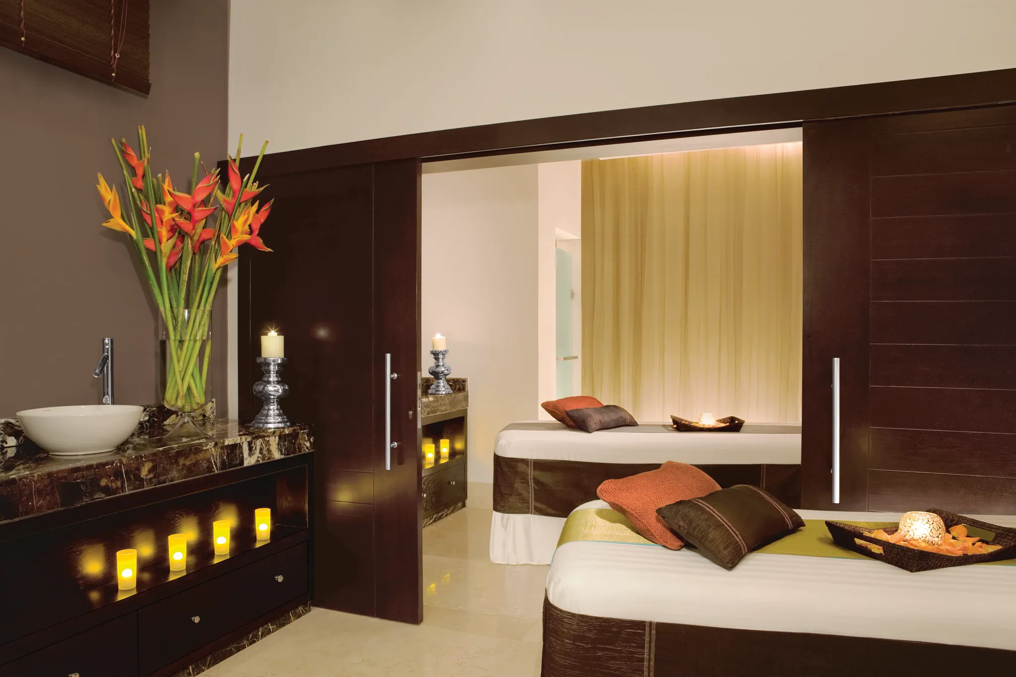 Tranquil spa treatment room with massage beds and candles at Secrets St. James Montego Bay spa.
